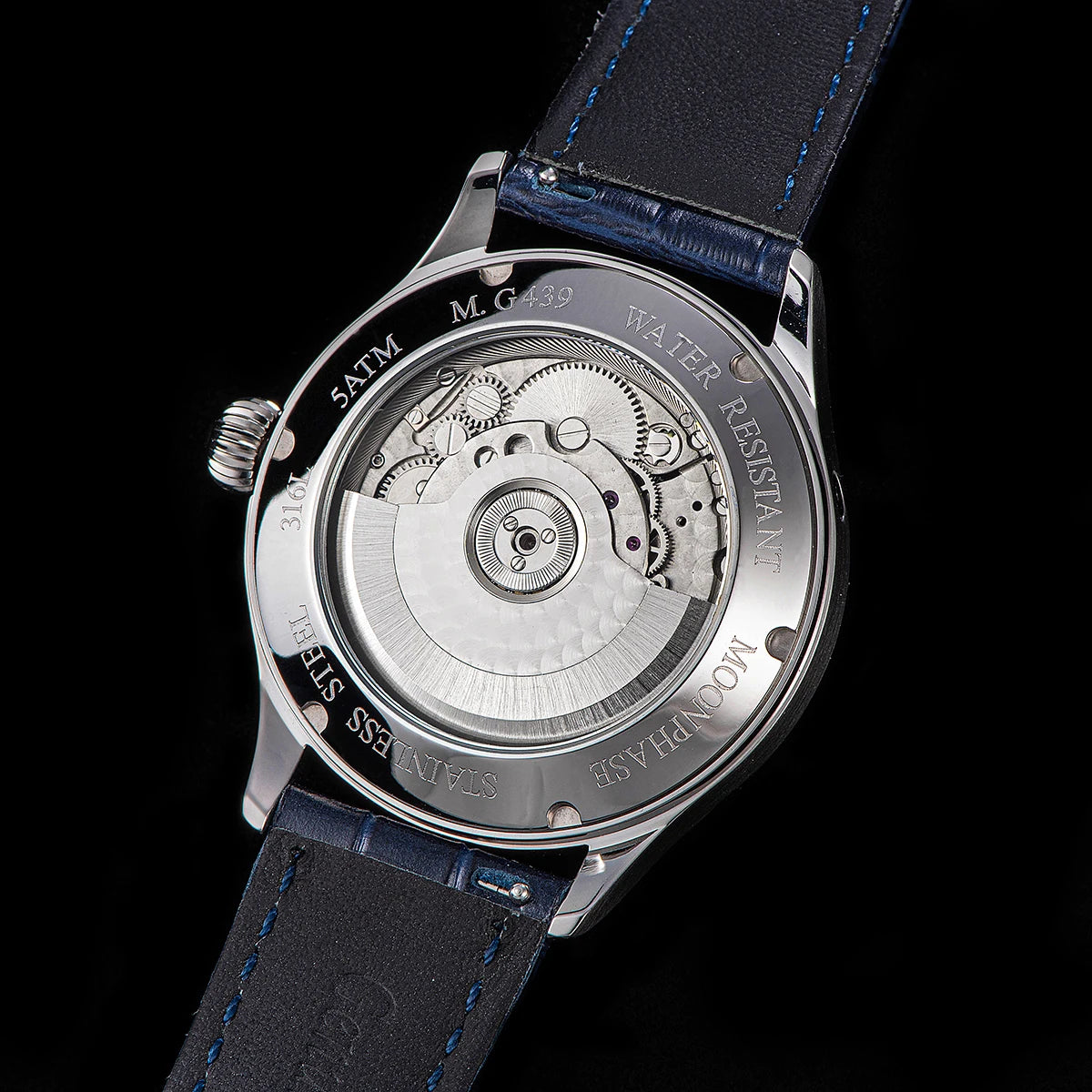 Watch back cover with mechanical components on a black background