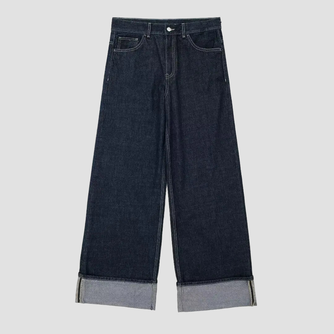 Dark blue wide-leg jeans with cuffed hems on a white background