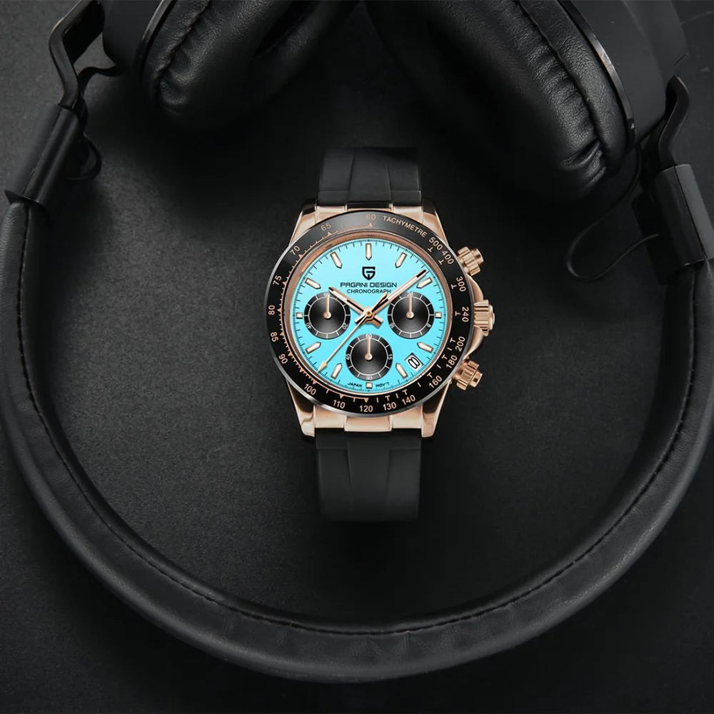 Luxury watch with blue face and black strap on a dark surface with headphones
