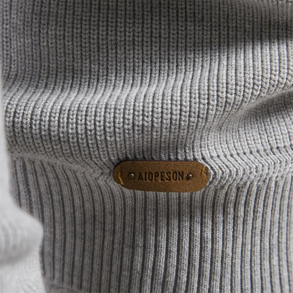 Close-up of a gray textured fabric with a brown leather label featuring 'Aldo Pesson'.