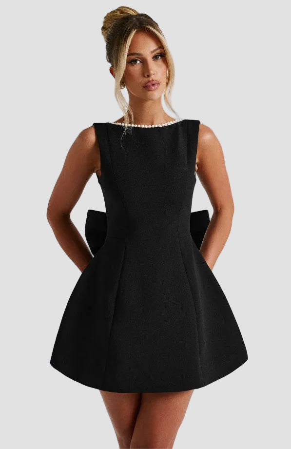 Woman wearing a black dress against a plain background