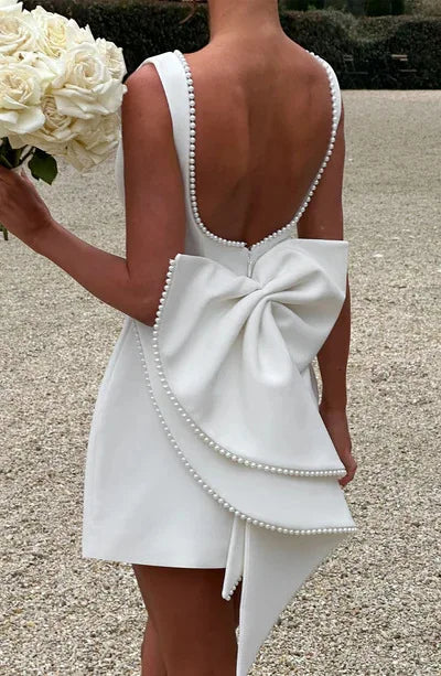 White dress with a large bow detail on a gravel path