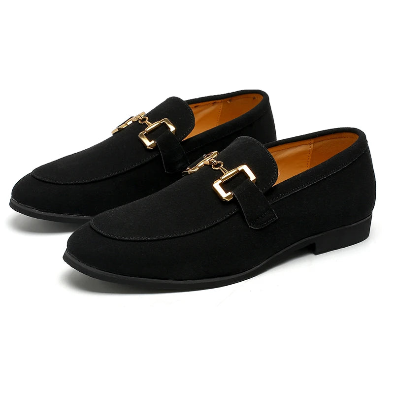 Pair of black loafers with gold buckles on a white background