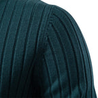 Close-up of a teal ribbed sweater sleeve on a white background