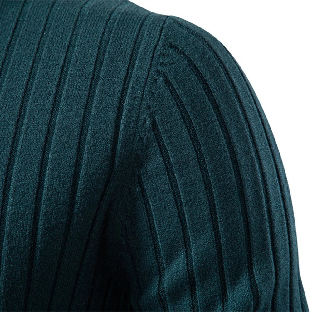 Close-up of a teal ribbed sweater sleeve on a white background
