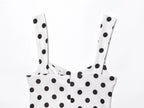 White top with black polka dots on a white background