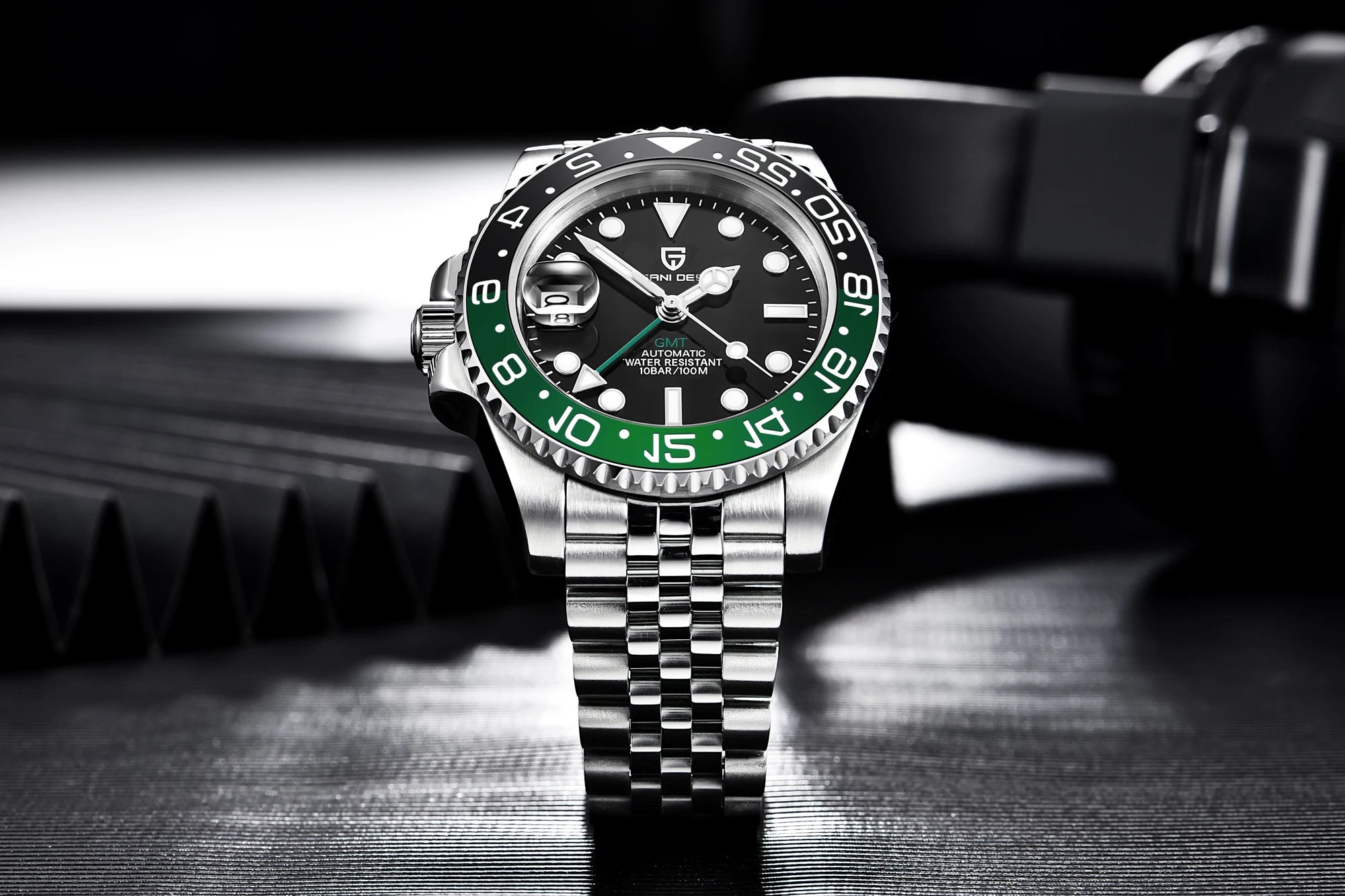 Luxury watch with black face and green bezel on a dark background