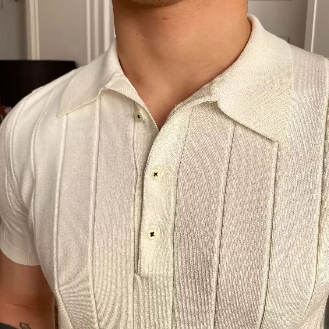 Man wearing the Cannes ribbed polo with white trousers at a seaside resort.