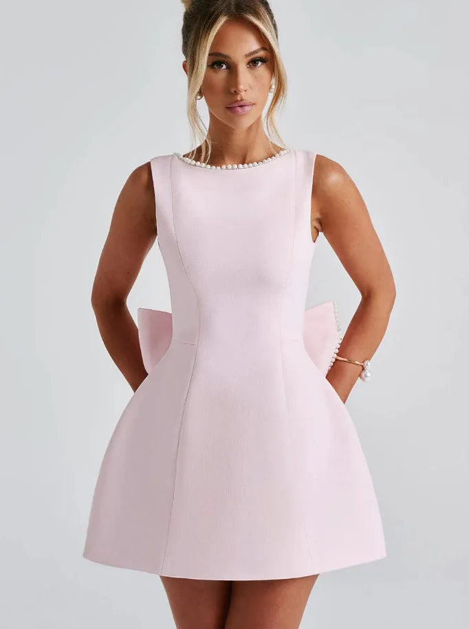 Woman wearing a light pink dress against a plain background