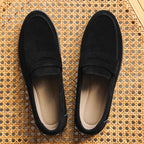 Pair of black loafers on a textured woven surface