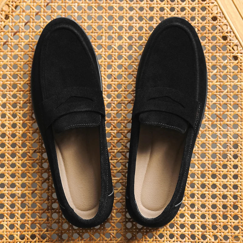 Pair of black loafers on a textured woven surface