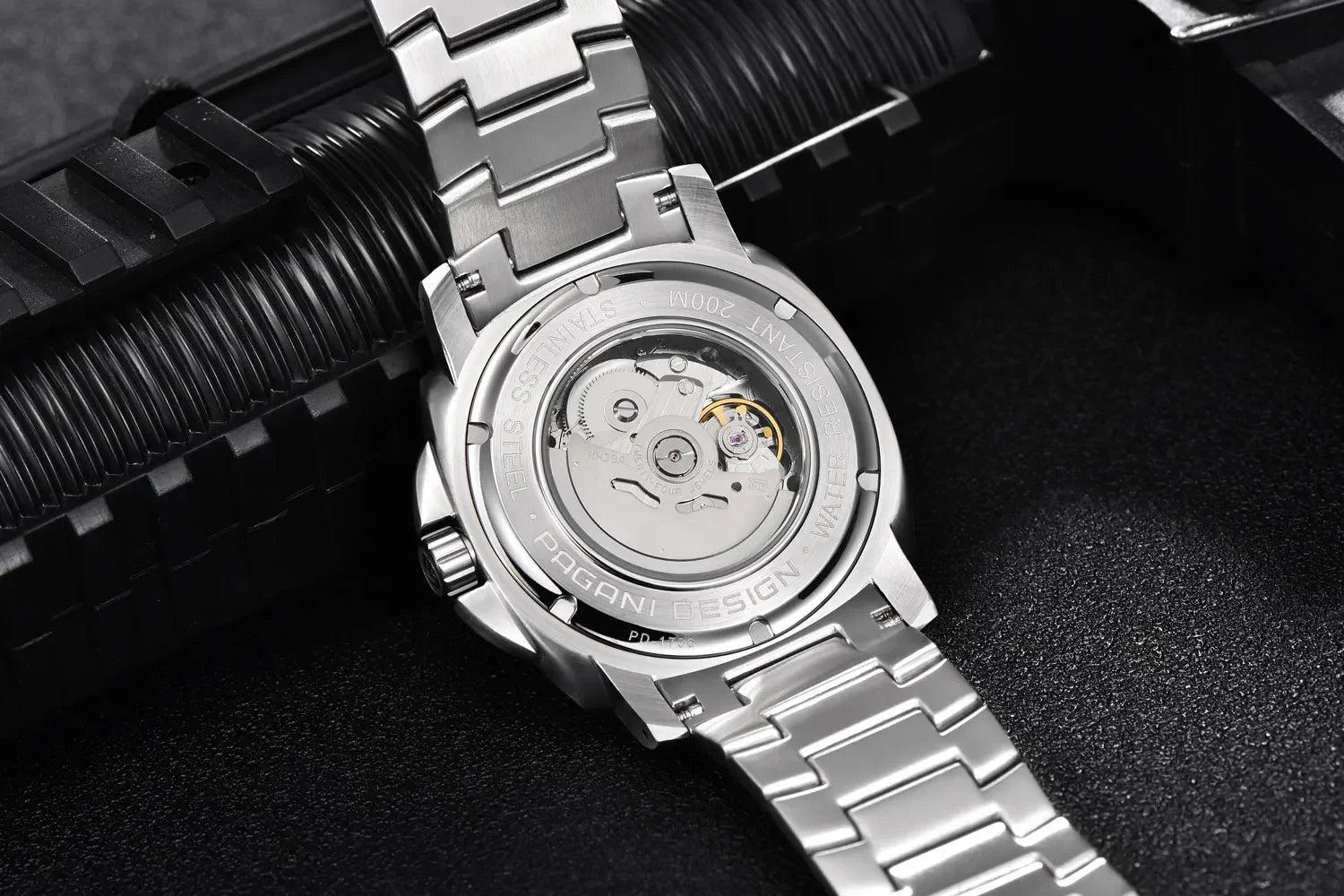 Close-up of a silver watch with mechanical components on a dark background