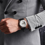 Person wearing a watch on a gray coat with black buttons