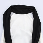 Black scarf draped over a white background