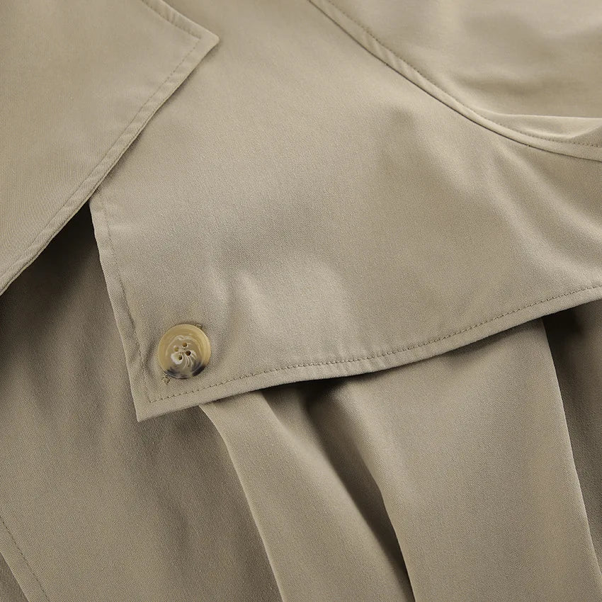 Close-up of a beige trench coat with a button