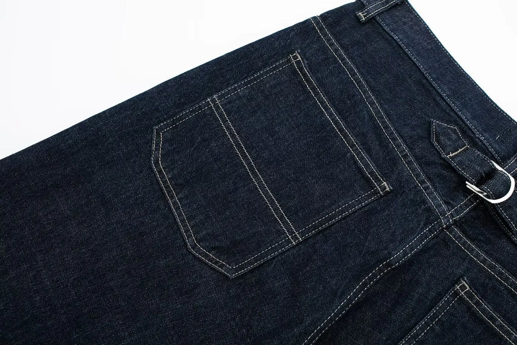 Close-up of dark blue denim jeans with a white background