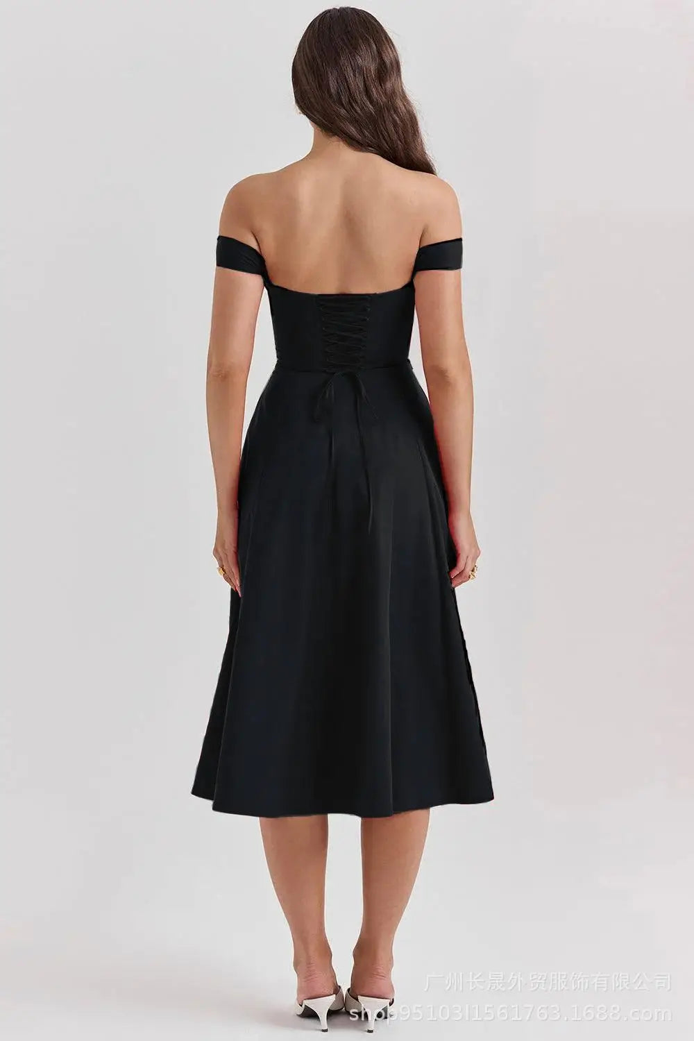 Black off-shoulder dress worn by a model on a white background