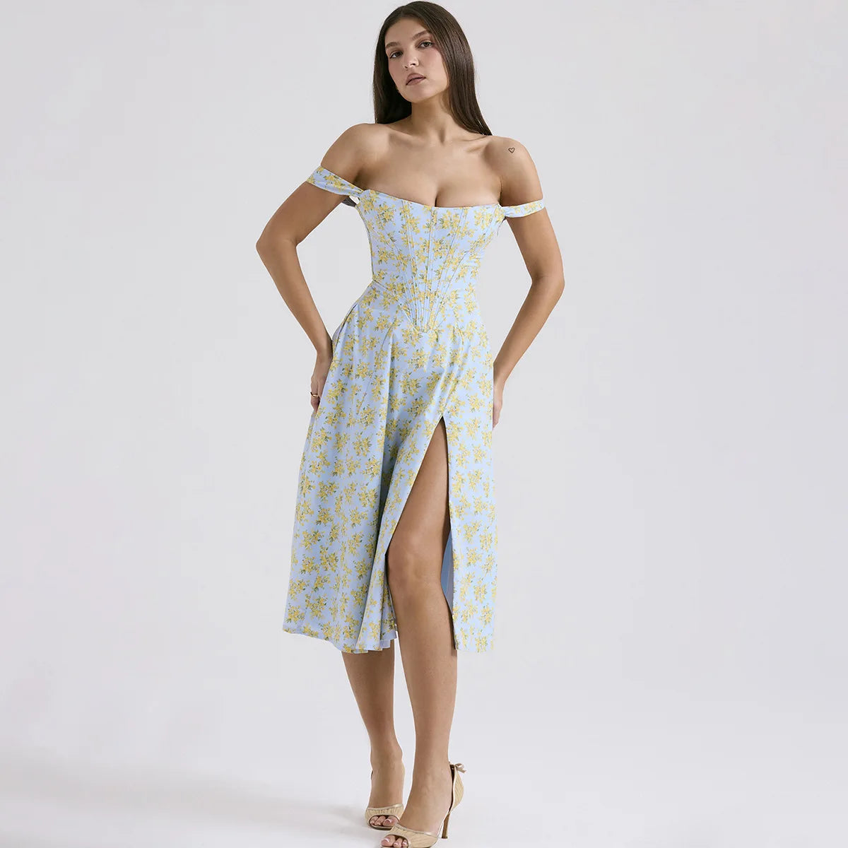 Woman wearing a light blue floral off-shoulder dress with a slit on a white background