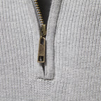 Close-up of a textured gray fabric with a zipper detail.