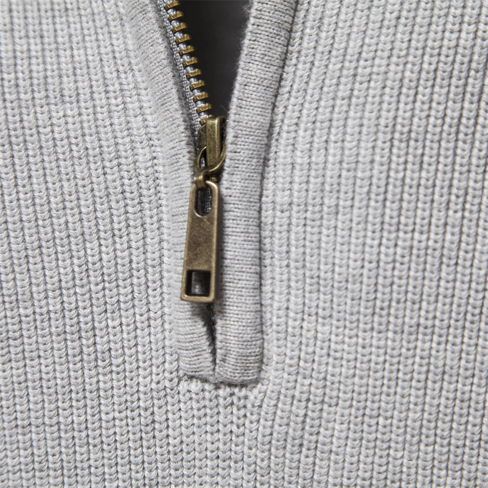 Close-up of a textured gray fabric with a zipper detail.