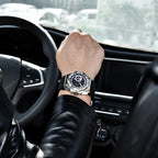 Person wearing a watch inside a car with a blurred background