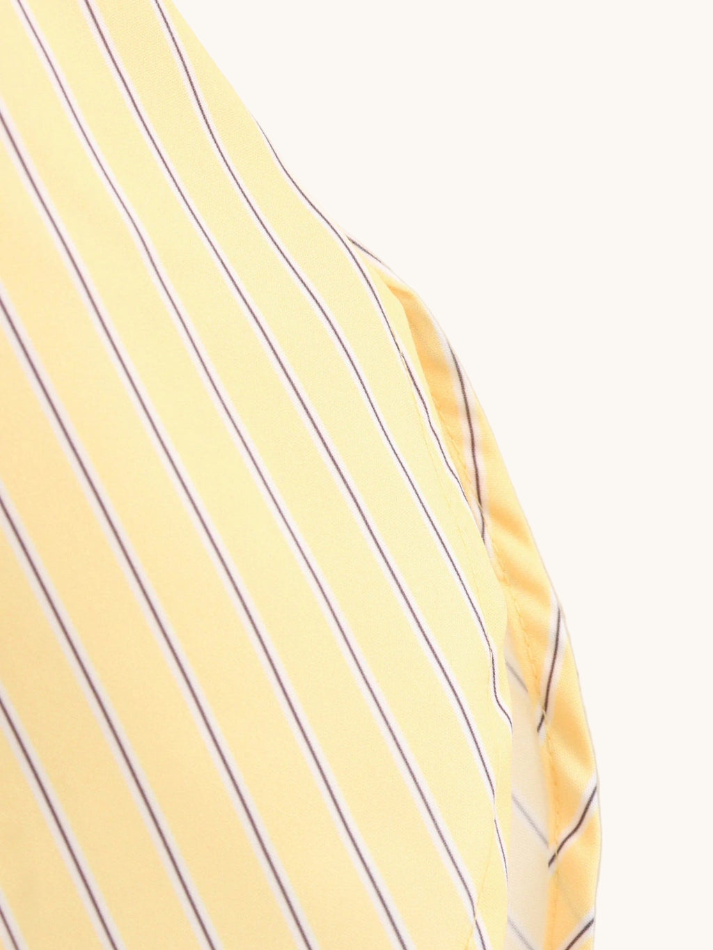 Close-up of a yellow shirt with blue stripes on a plain background