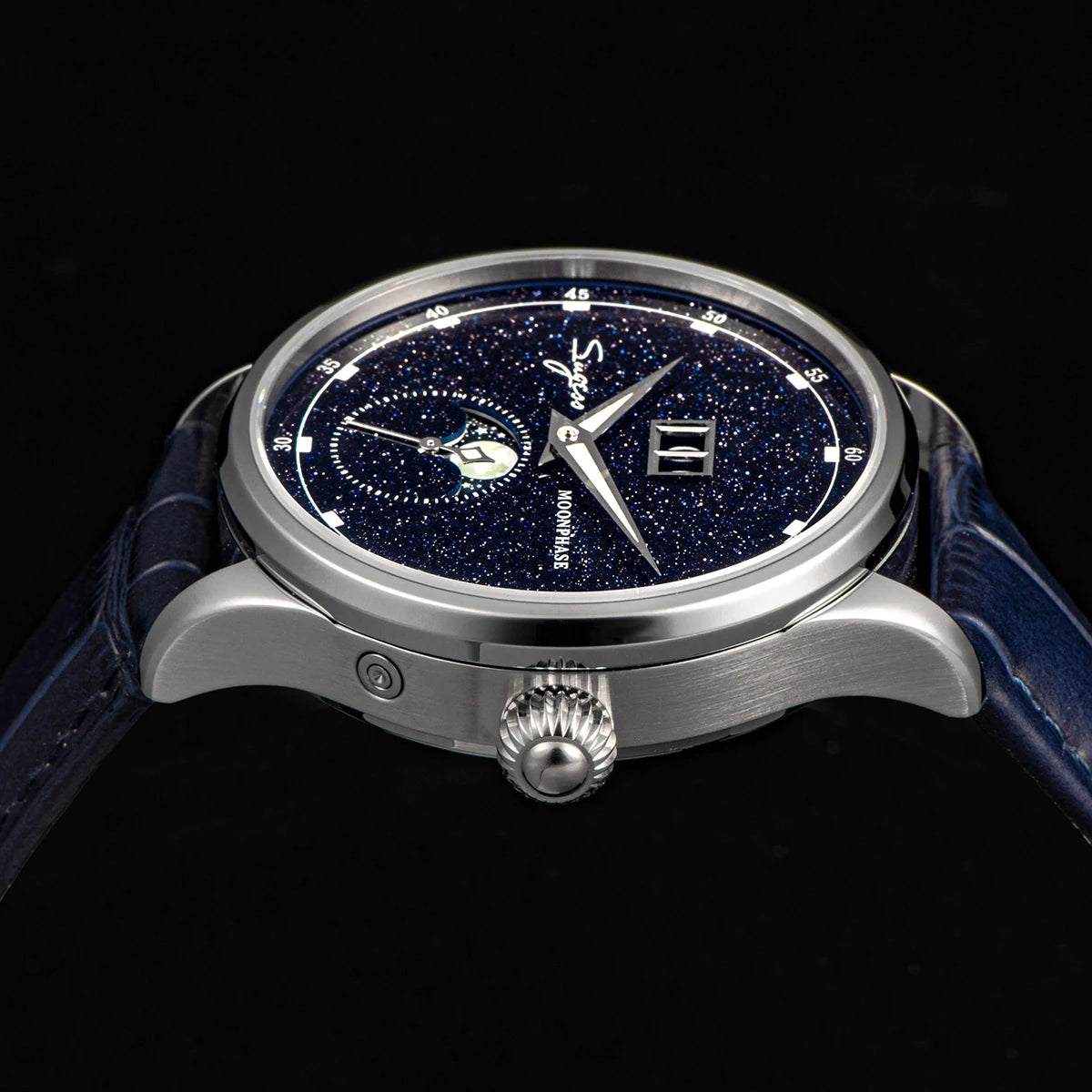 Luxury watch with blue strap and starry dial on a black background