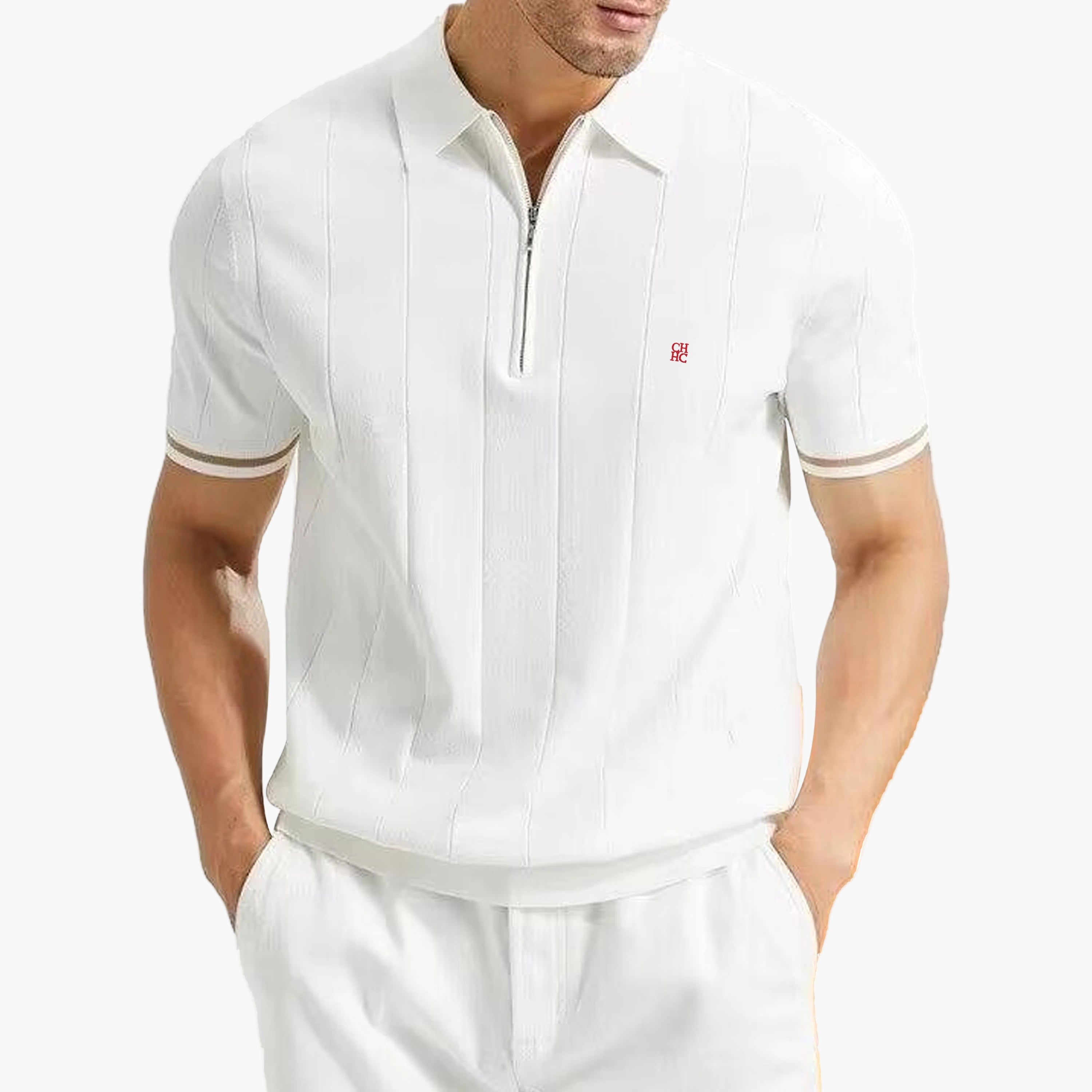 Man wearing a white polo shirt with a small logo on a white background