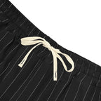 Black pinstripe shorts with a white drawstring on a white background