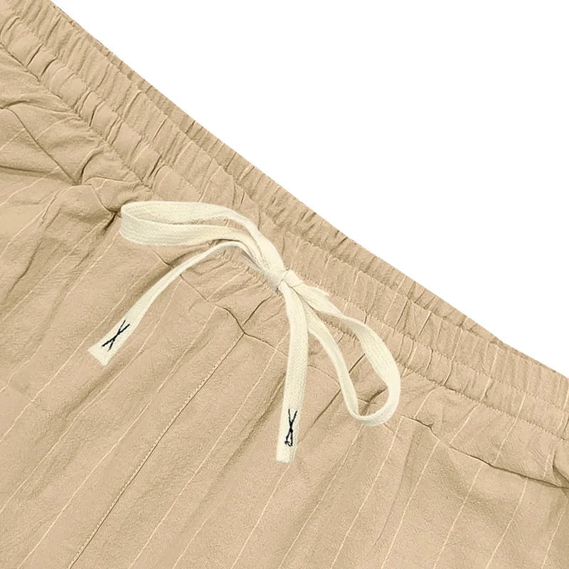 Beige shorts with drawstring and brand logo on a white background