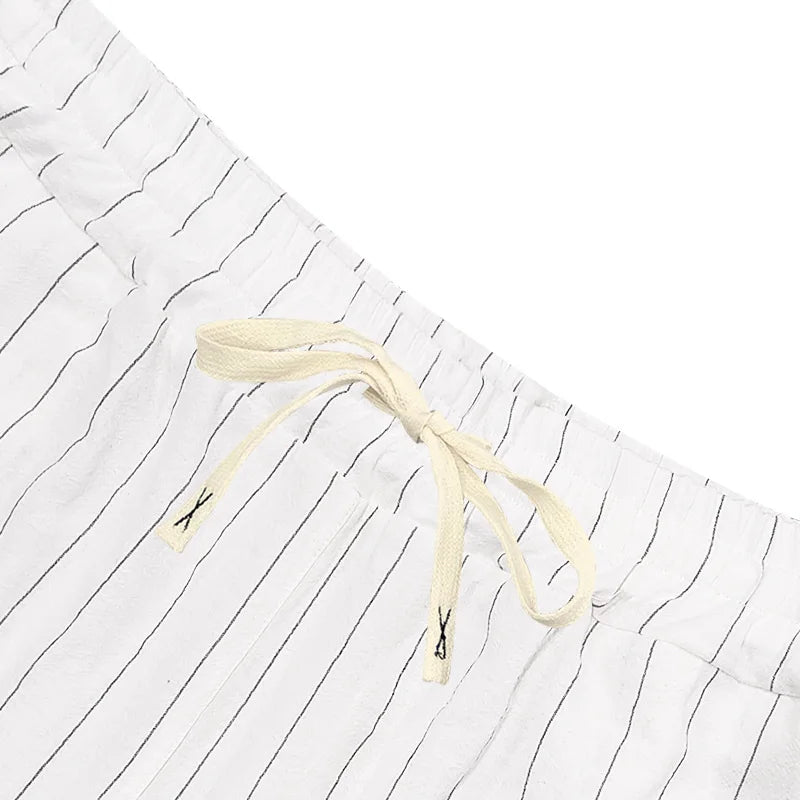 White shorts with black stripes and a drawstring on a white background