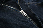 Close-up of a zipper on a dark blue denim fabric