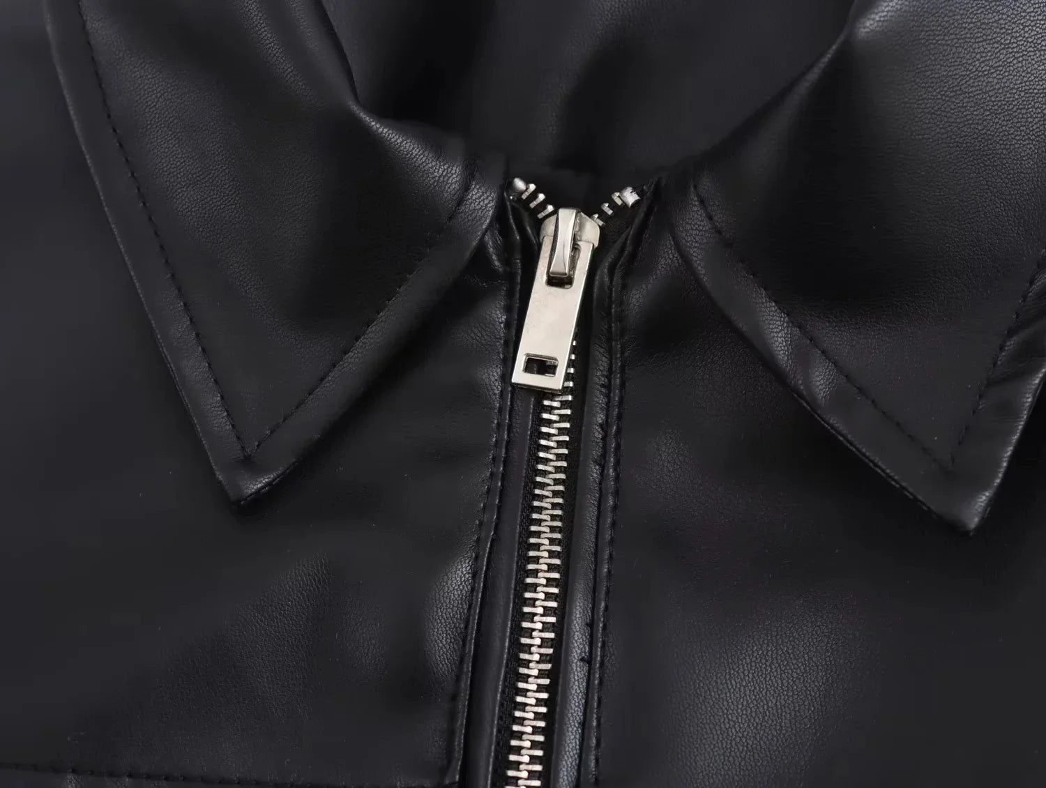 Close-up of a black leather jacket with a zipper