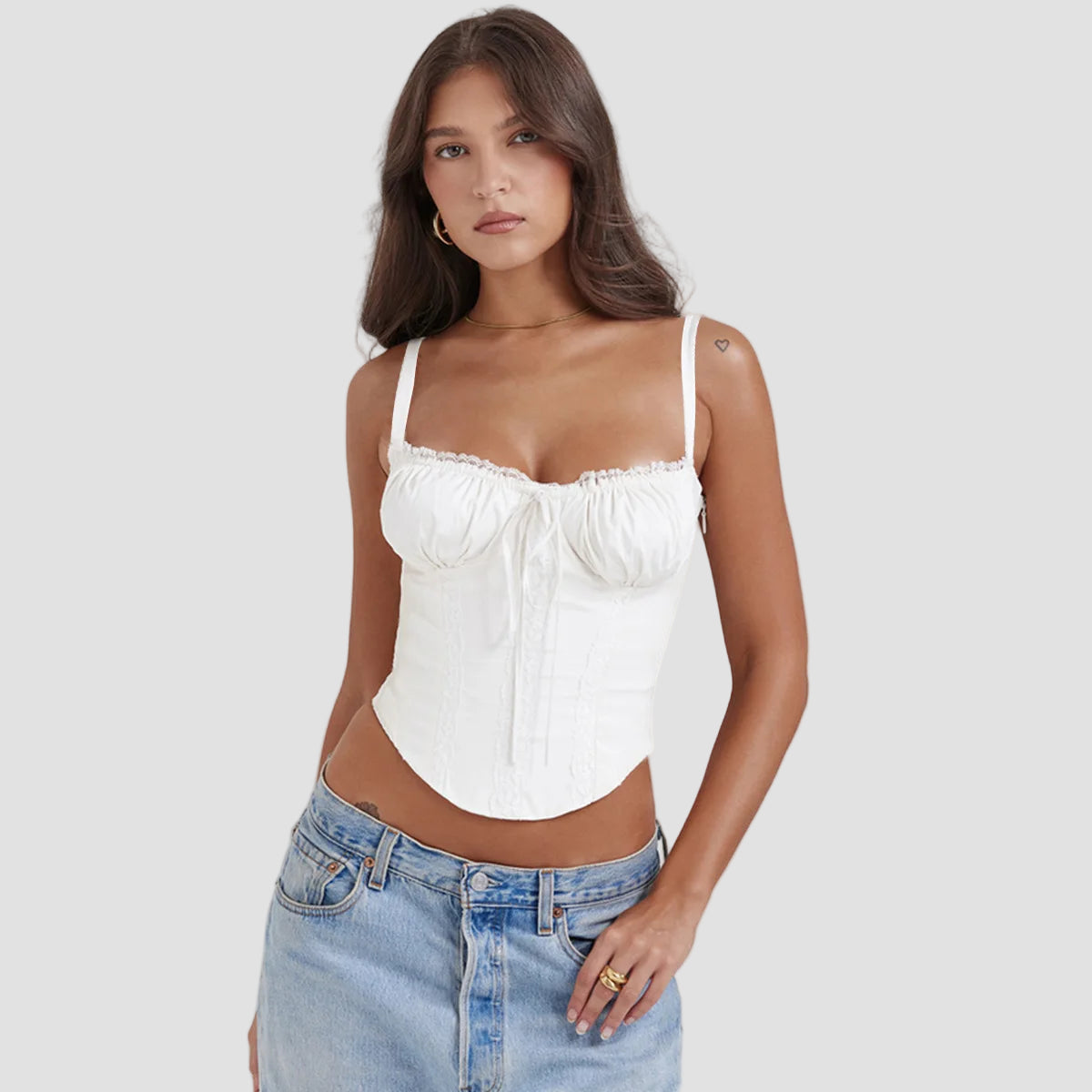 Woman wearing the Altivieri 'The Florence' white corset top with high-waisted blue jeans.