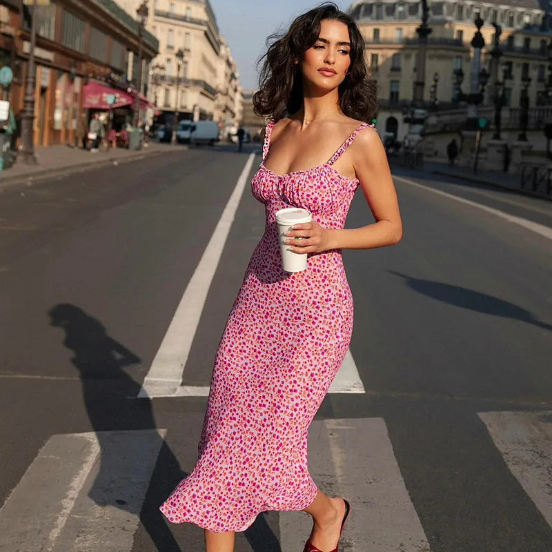 Woman wearing the Altivieri 'The Positano' pink floral midi sundress in a summer setting.