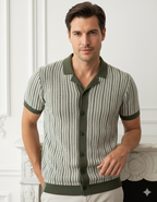 Man wearing a patterned green and white shirt against a white wall.